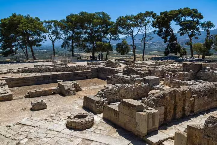 Explore the ancient ruins of Phaistos in Crete, surrounded by lush greenery and overlooking a scenic valley.