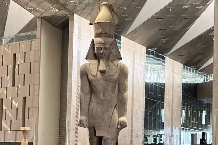 Colossal pharaoh statue in the Grand Egyptian Museum atrium on private Giza tour with pyramids and Sphinx