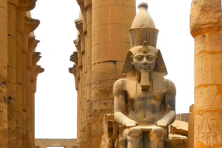 Seated pharaoh statue at Karnak Temple columns, Luxor highlights on private Cairo to Luxor plane day trip