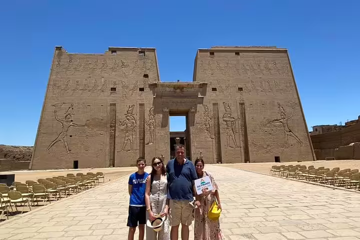 Travelers at Philae Temple entrance in Aswan, Egypt on a private guided tour, with carved pylons behind