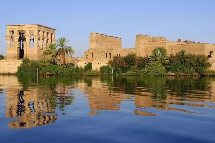 Philae Temple on the Nile in Aswan with palm trees and reflections, Egypt Nile cruise tour from Cairo