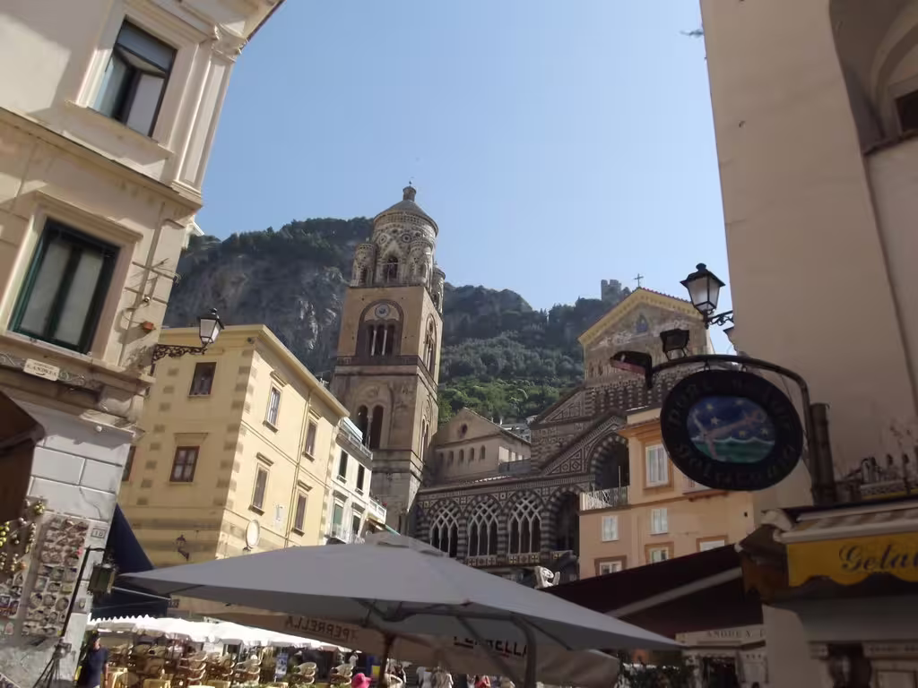 Piazza Duomo in Amalfi with the medieval Amalfi Cathedral, bell tower and lively cafés on a sunny Amalfi Coast day tour