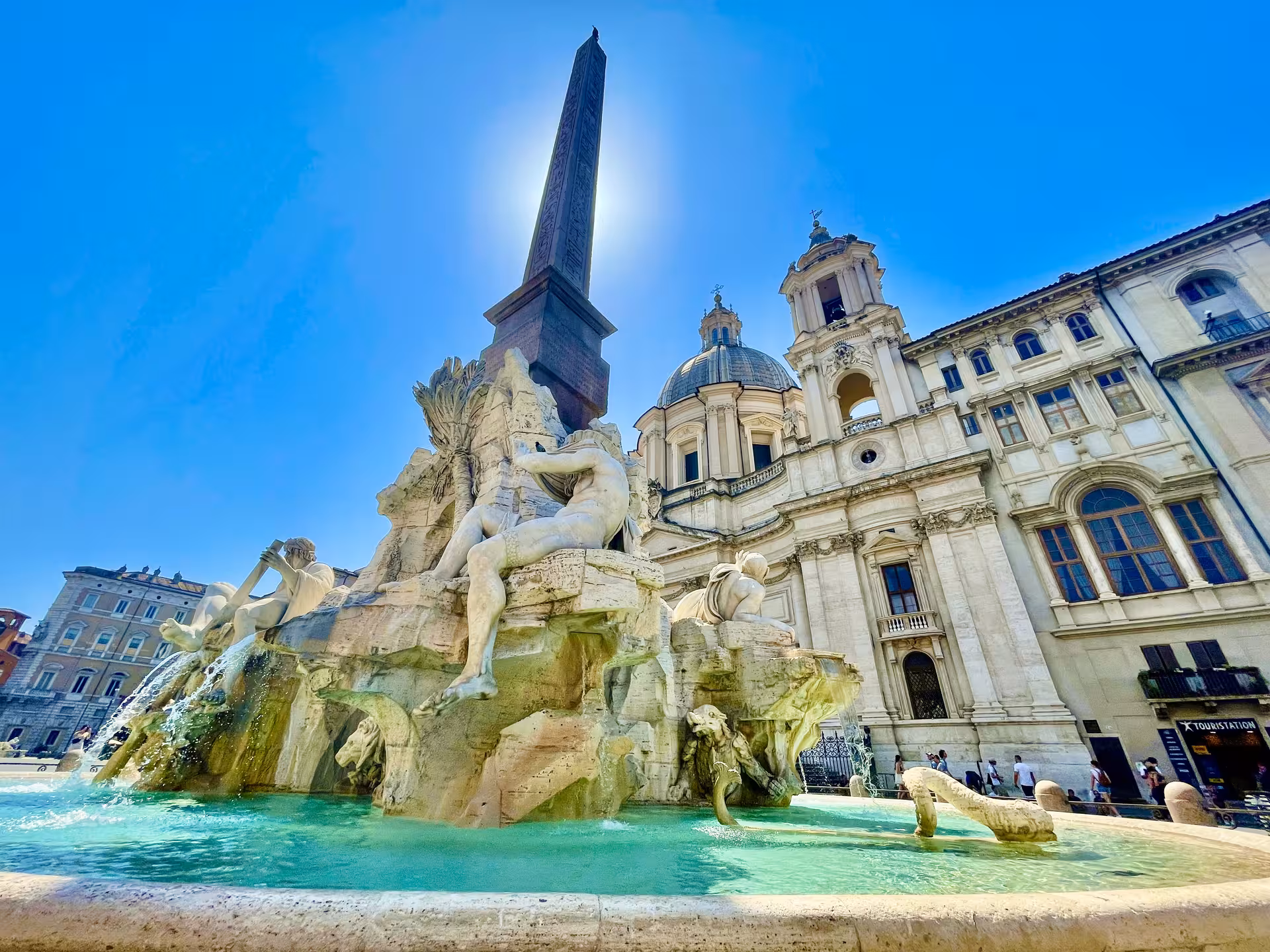 Sunlit Fountain of the Four Rivers and obelisk in Piazza Navona, visited on the Civitavecchia to Rome VIP tour