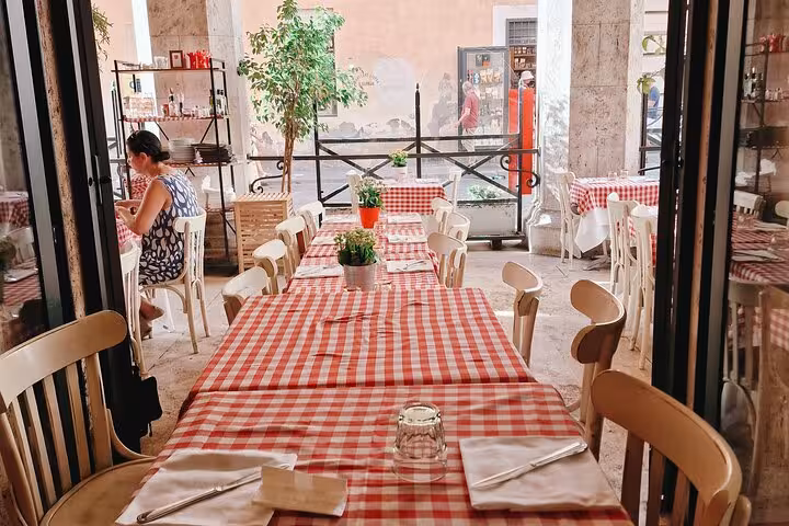 Charming Italian restaurant in Piazza Navona, Rome, with red checkered tablecloths set for an authentic dining experience.