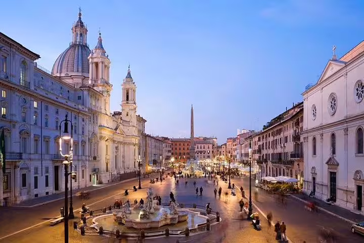 Evening view of Piazza Navona in Rome with Baroque churches, fountains and lively crowds on a private full-day city tour