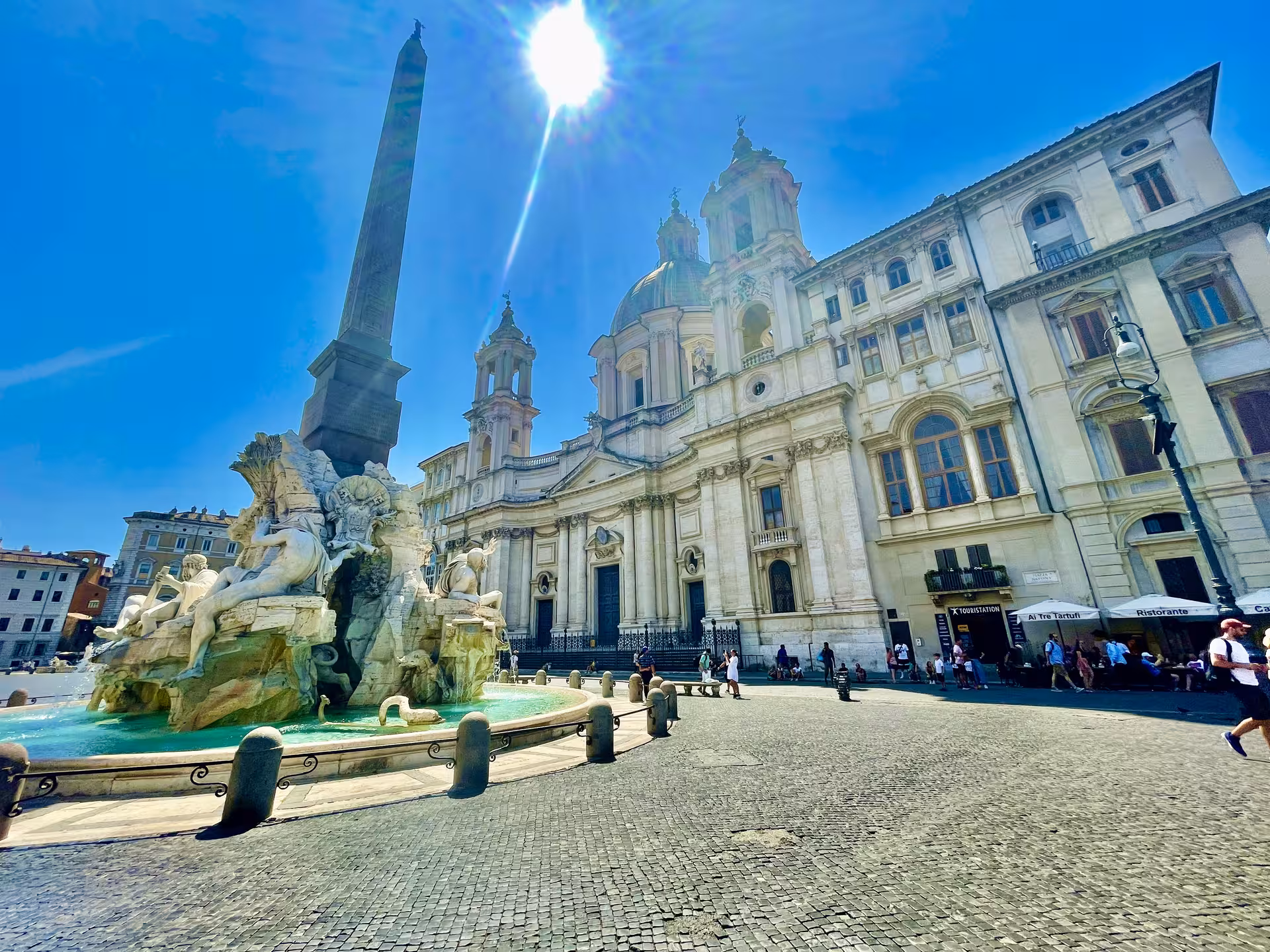 Sunlit Piazza Navona with Fontana dei Quattro Fiumi and baroque church on VIP shore excursion from Civitavecchia to Rome