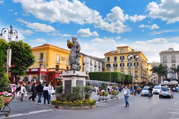 Bustling Piazza Tasso in Sorrento, Italy, with historic buildings and a statue, perfect for a guided walking tour.