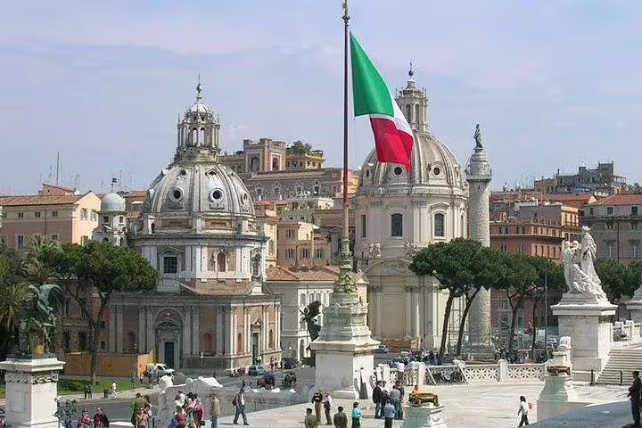 Piazza Venezia with Italian flag and historic churches in central Rome, visited on a private Best of Rome day tour