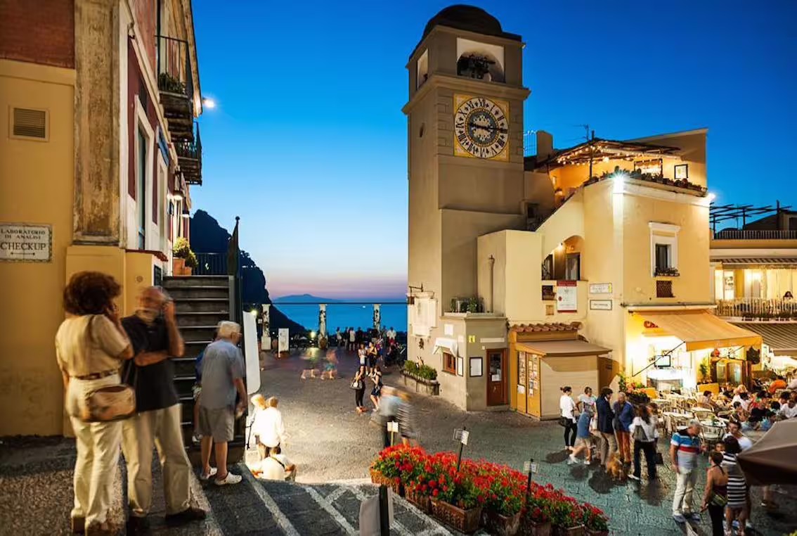 Piazzetta di Capri at dusk with iconic clock tower, a highlight of the Naples to Capri small-group ferry tour