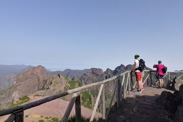 Hikers admire the stunning mountain vistas from the viewpoint at Pico do Arieiro, ideal for nature photography.