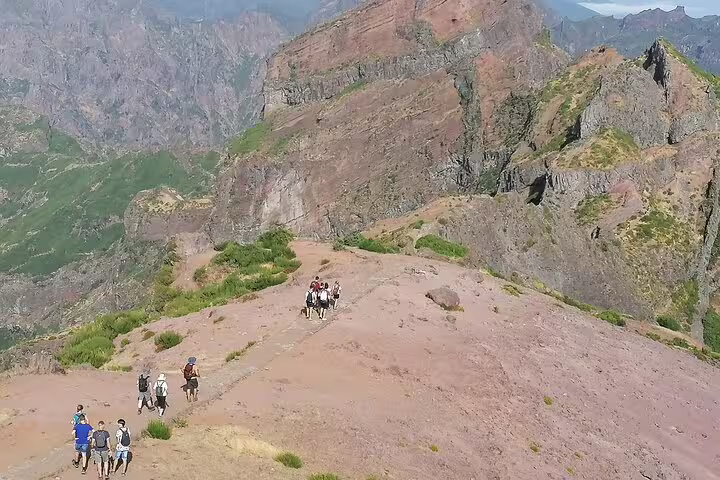 Hikers traverse the rugged trails of Pico do Arieiro with stunning mountain views in Madeira's scenic landscape.