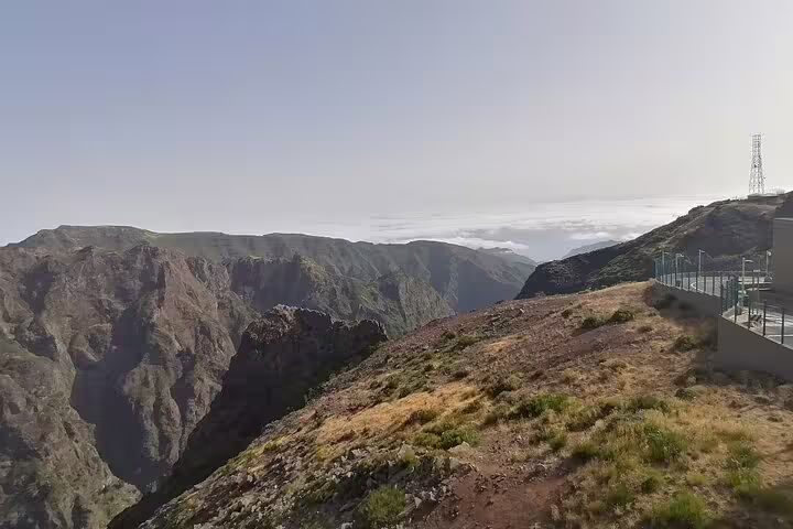 Breathtaking view from Pico do Arieiro with rugged mountain landscapes stretching under clear blue skies.