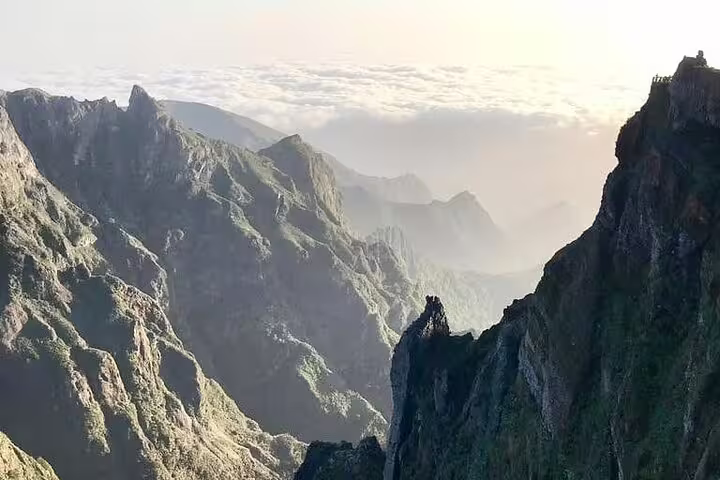 Panoramic view of jagged mountain ridges at Pico do Arieiro under a clear sky, ideal for a morning hike adventure.