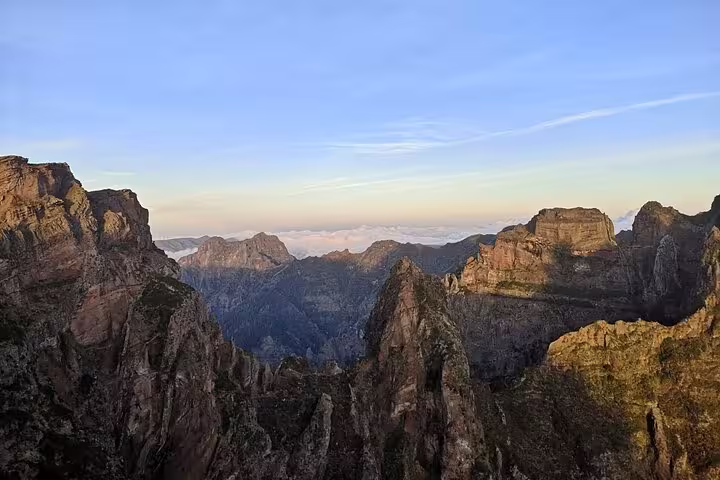 Breathtaking sunrise over jagged peaks of Pico do Arieiro, showcasing Madeira's dramatic mountain landscape.