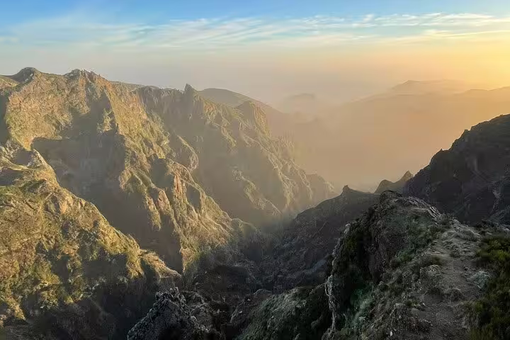 Breathtaking sunrise view from Pico do Arieiro overlooking rugged mountain peaks and misty valleys in Madeira.