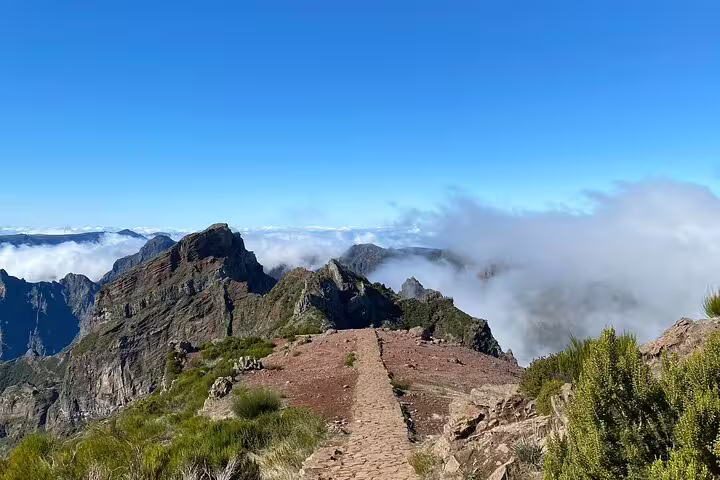 Stone path leading to breathtaking views above the clouds at Pico do Arieiro, ideal for a sunrise hiking adventure.
