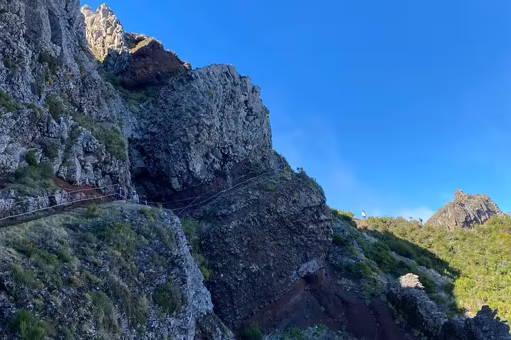 Rocky trail along Pico do Arieiro with lush greenery and clear blue skies on the self-guided sunrise hike.