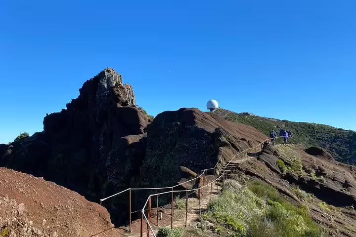 Trail leading up rocky slopes under clear blue skies on Pico do Arieiro sunrise hike, perfect for adventure seekers.