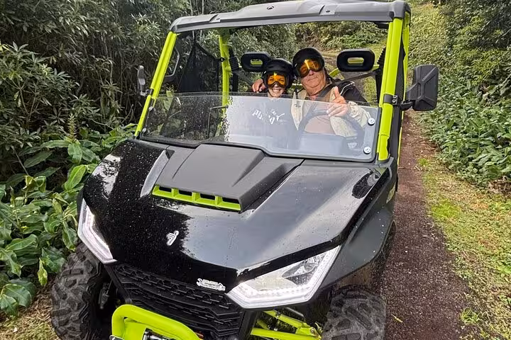 Smiling participants navigate dense foliage during a 3H buggy tour on Pico Island vineyards.