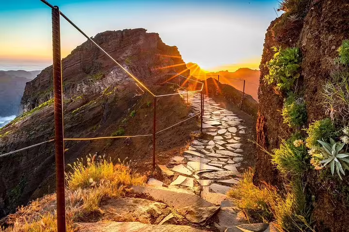 Breathtaking sunrise over Pico Ruivo's stone path, offering a stunning hiking experience in Madeira's mountain trails.