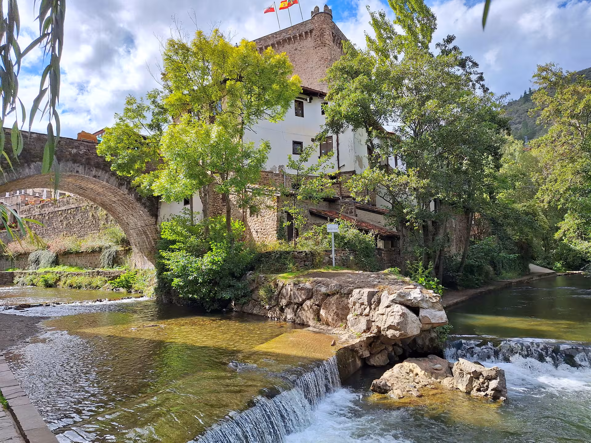 Charming stone bridge and river scene in Potes, perfect for Picos de Europa guided tours from Santander.