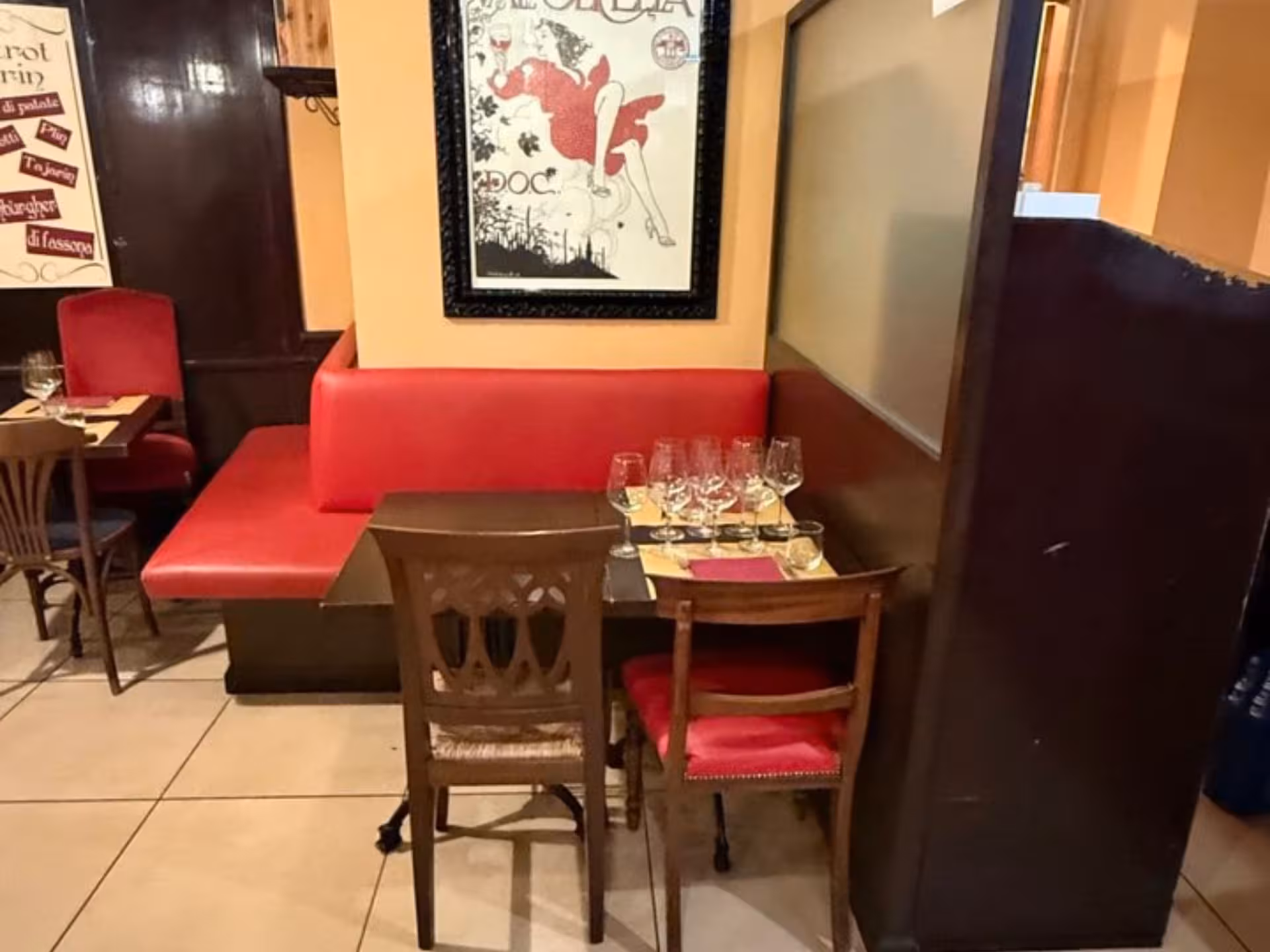 Intimate dining setup with red seating and wine glasses, ideal for enjoying Piedmontese tapas in Turin.
