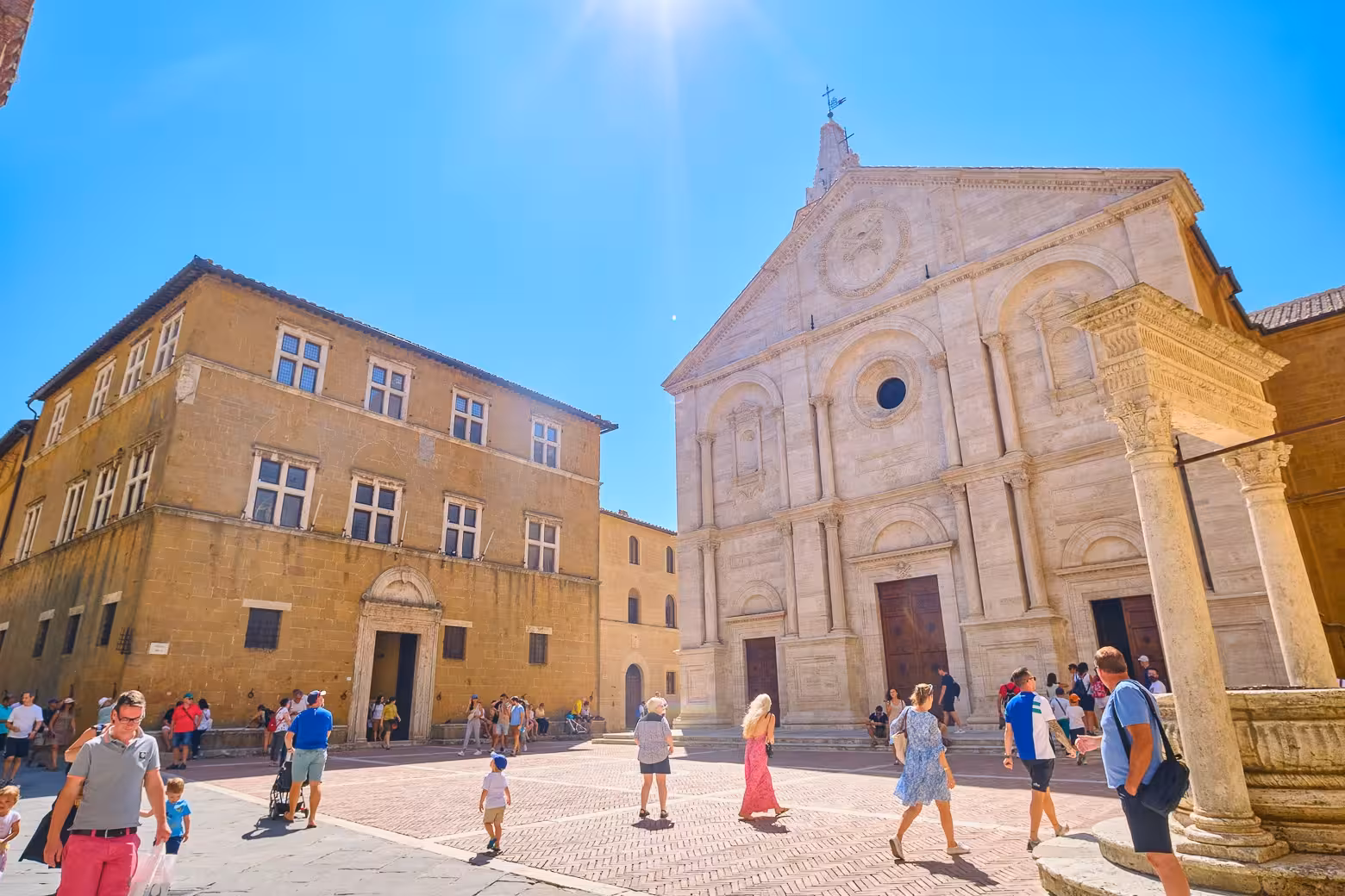 People wander around the picturesque Piazza Pio II in Pienza, featuring the stunning Pienza Cathedral and classic Tuscan architecture.