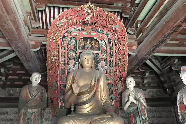 Buddhist statues adorned with ornate carvings in a Pingyao temple, featured on the Beijing to Xian bullet train tour.