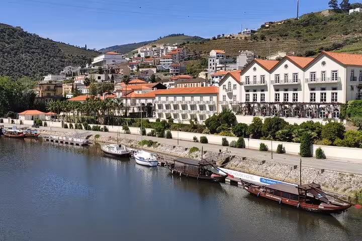 Riverside view of Pinhão on the Douro River with traditional rabelo boats and terraced vineyards in Portugal