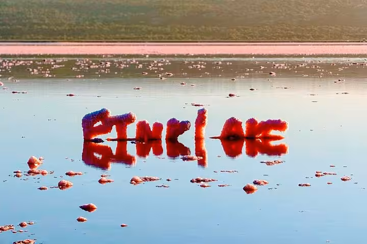 Salt formations reflecting in the tranquil waters of the Pink Lake at sunset on the 2 Days One Night Tour.