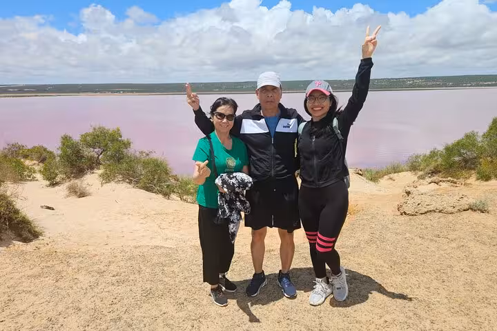 Visitors posing with peace signs at Pink Lake lookout, highlighting the 2 Days One Night tour experience.