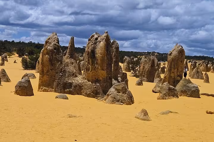 Unique limestone formations under dramatic clouds at the Pinnacles Desert in Nambung National Park.