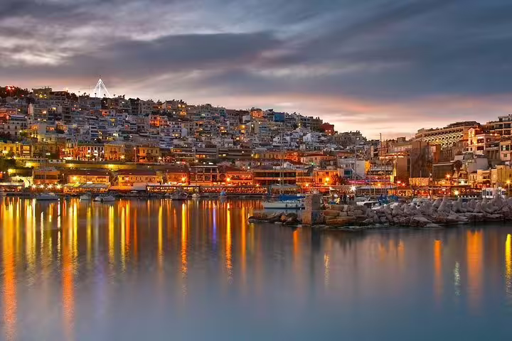 Piraeus harbor at sunset with city lights reflecting on the water, ideal add-on to an Athens night tour