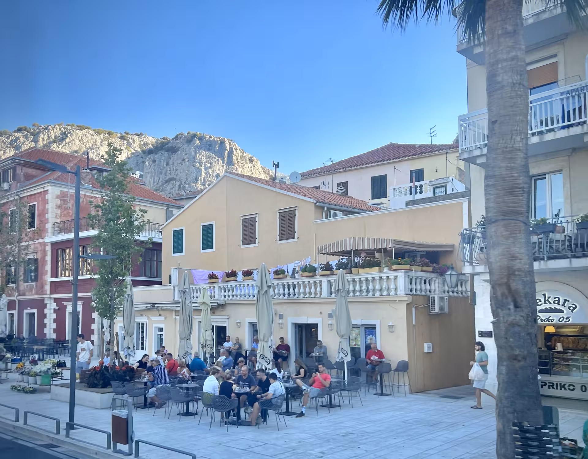 Omis old town waterfront cafe with Biokovo cliffs, a scenic stop on Pirates of Omis adults-only tour