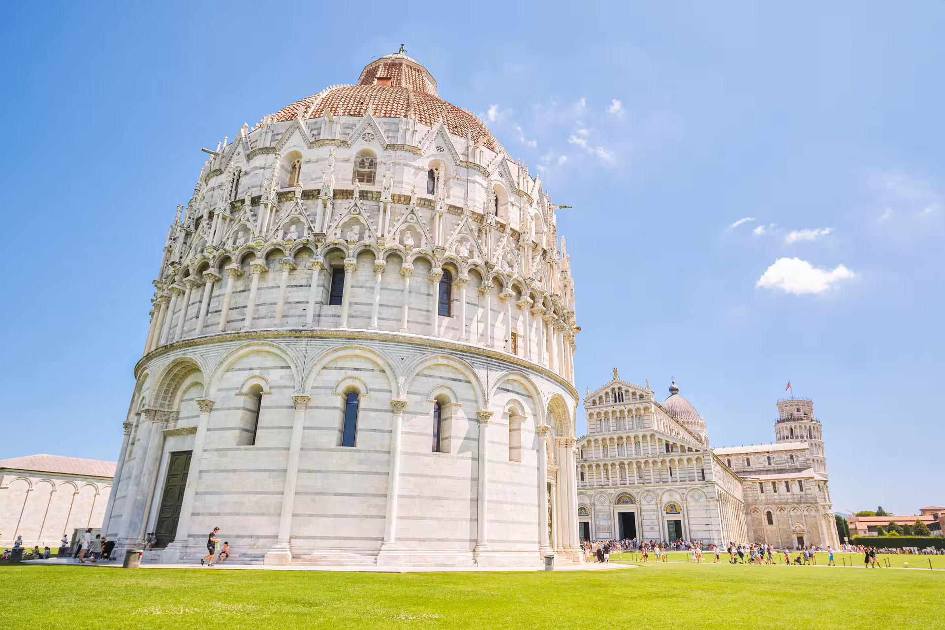 View of Pisa Baptistery and Leaning Tower under a clear blue sky, ideal for a day trip from Florence.