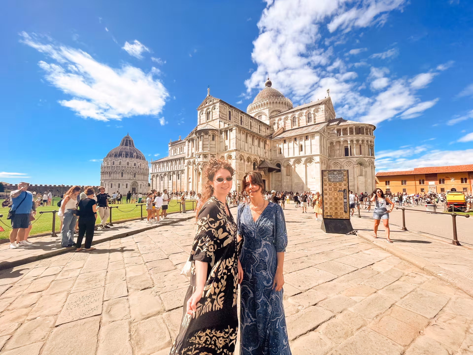 Tourists enjoying a sunny day at Pisa Cathedral and the Baptistery during a Florence to Pisa day tour.