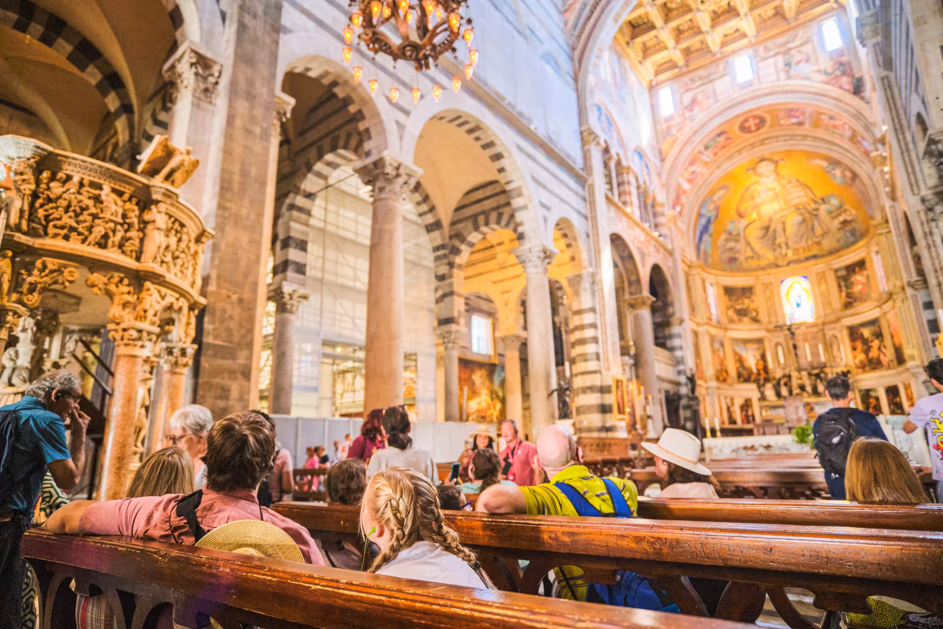 Tourists admire the intricate interior of Pisa Cathedral during a half-day shore excursion from Livorno.