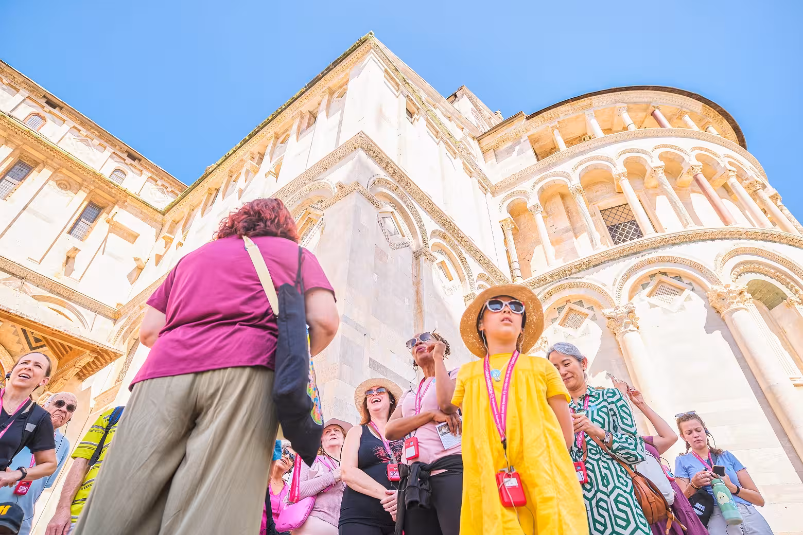 Tour group listens attentively at the Pisa Cathedral on a sunny day during the Piazza dei Miracoli half-day tour.