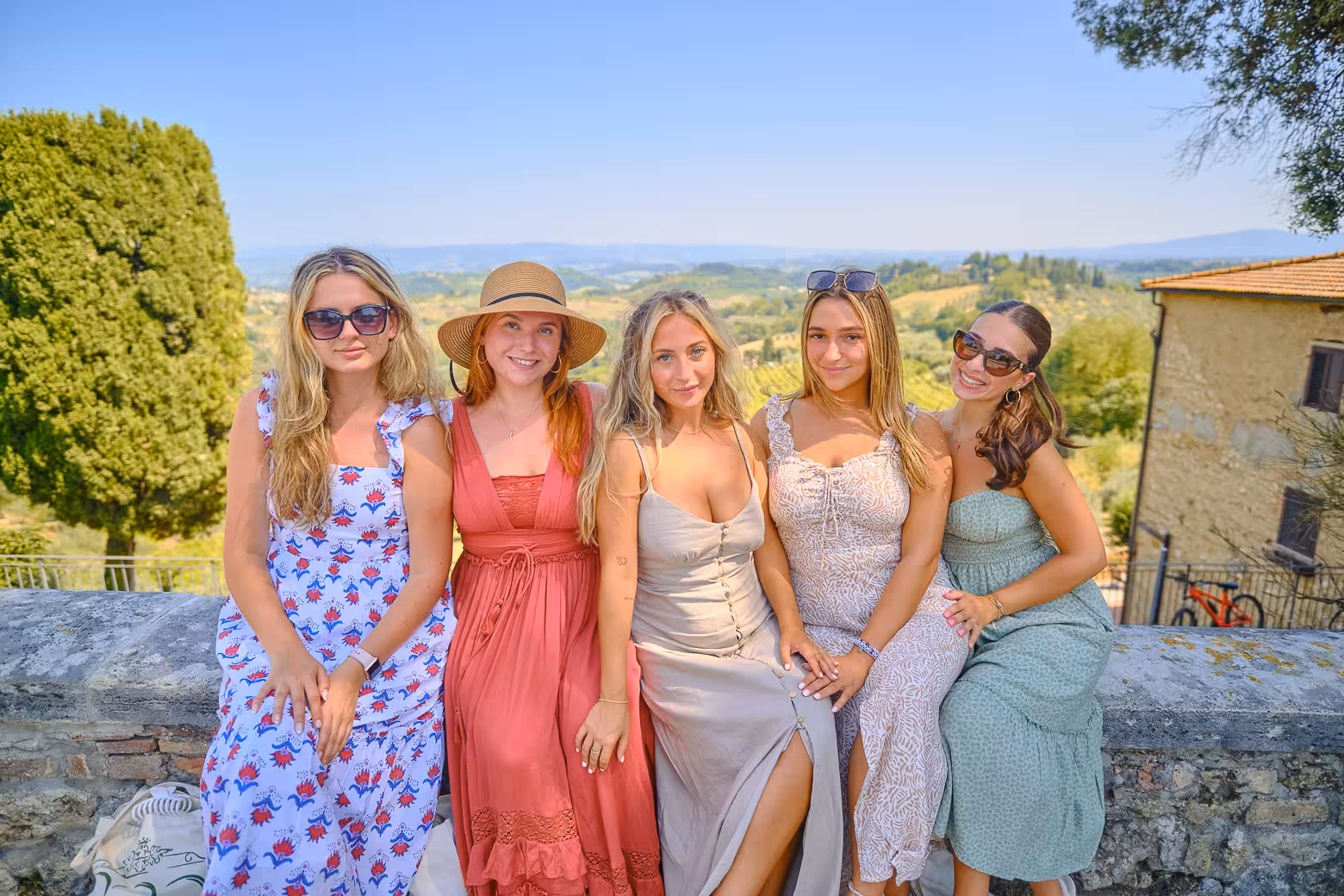 Group of friends enjoying the scenic view of Tuscany's hills on a Pisa, Siena, and San Gimignano day trip.