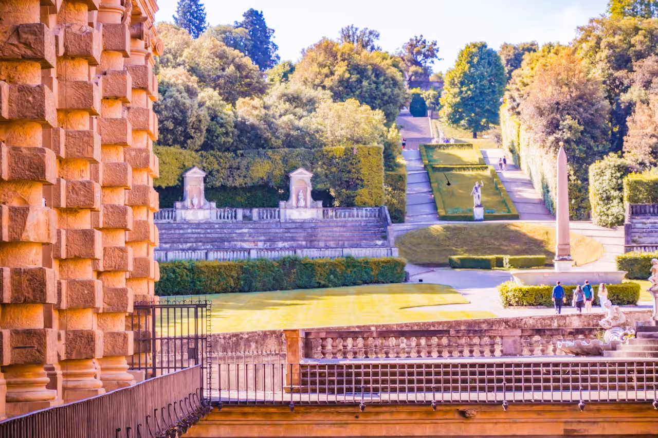 Elegant terraces and manicured paths of Boboli Gardens viewed from Pitti Palace, surrounded by vibrant greenery.