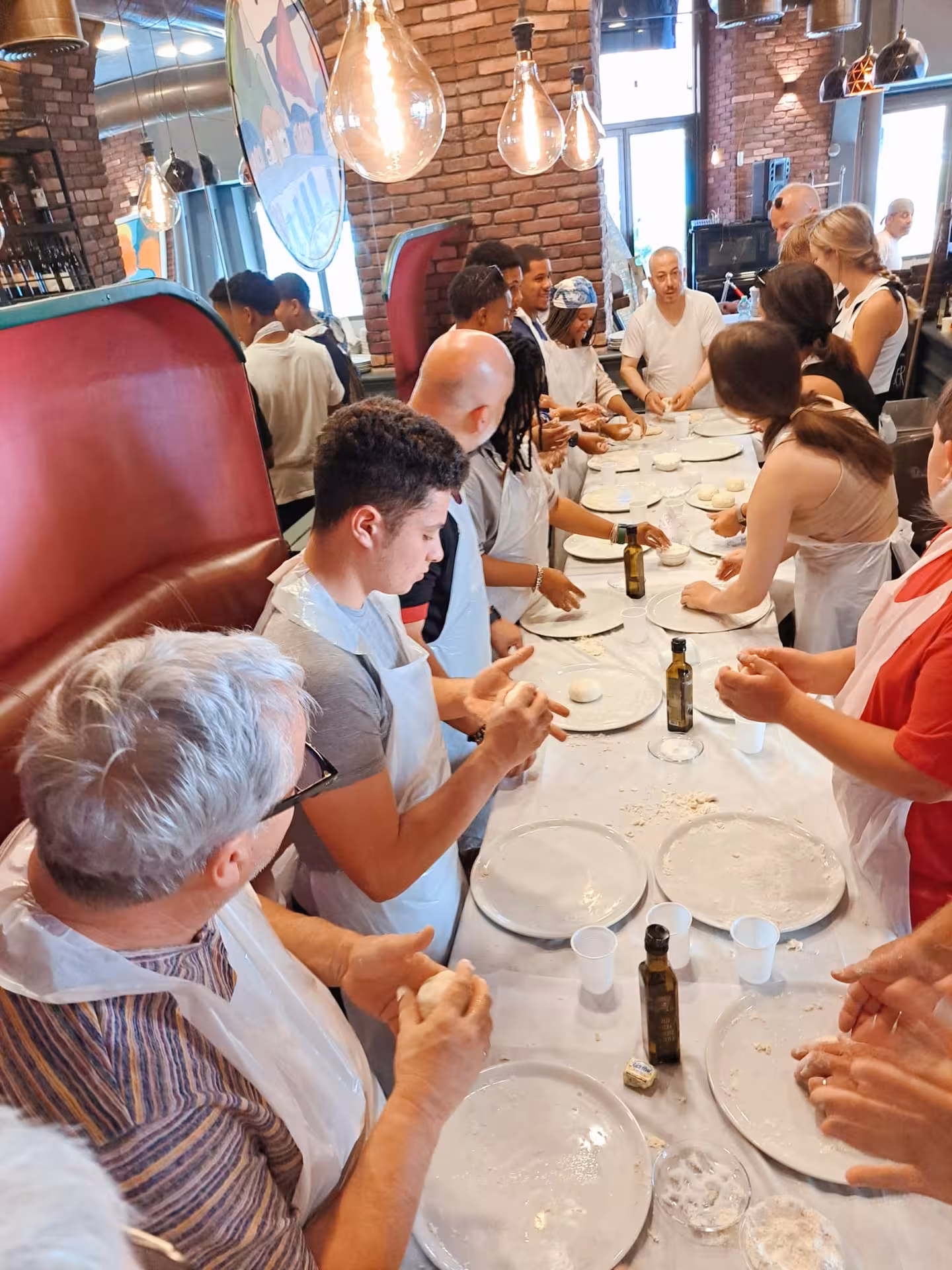 Participants shaping dough during a pizza cooking class at Jazz Cafe in Rome, showcasing a hands-on culinary experience.