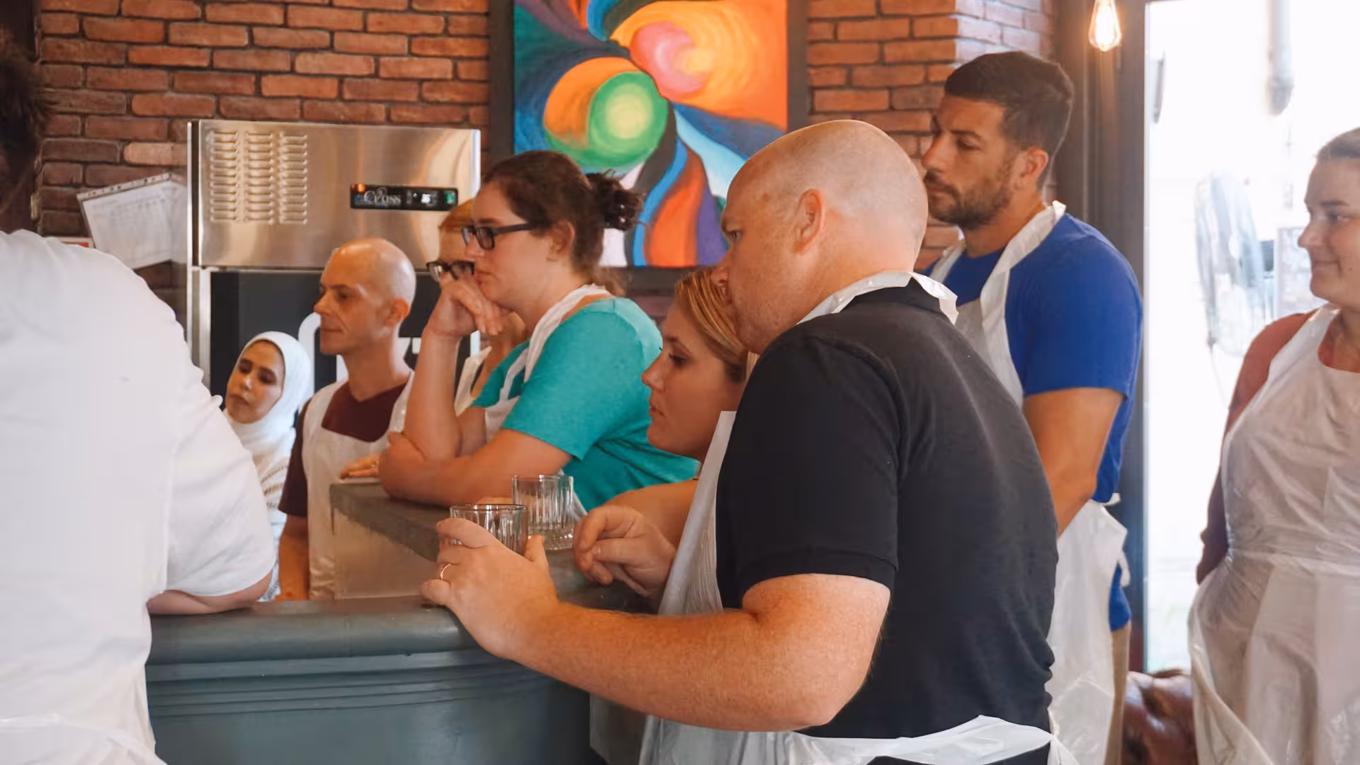 Group of people attentively listening during pizza cooking class at Jazz Cafe in Rome.