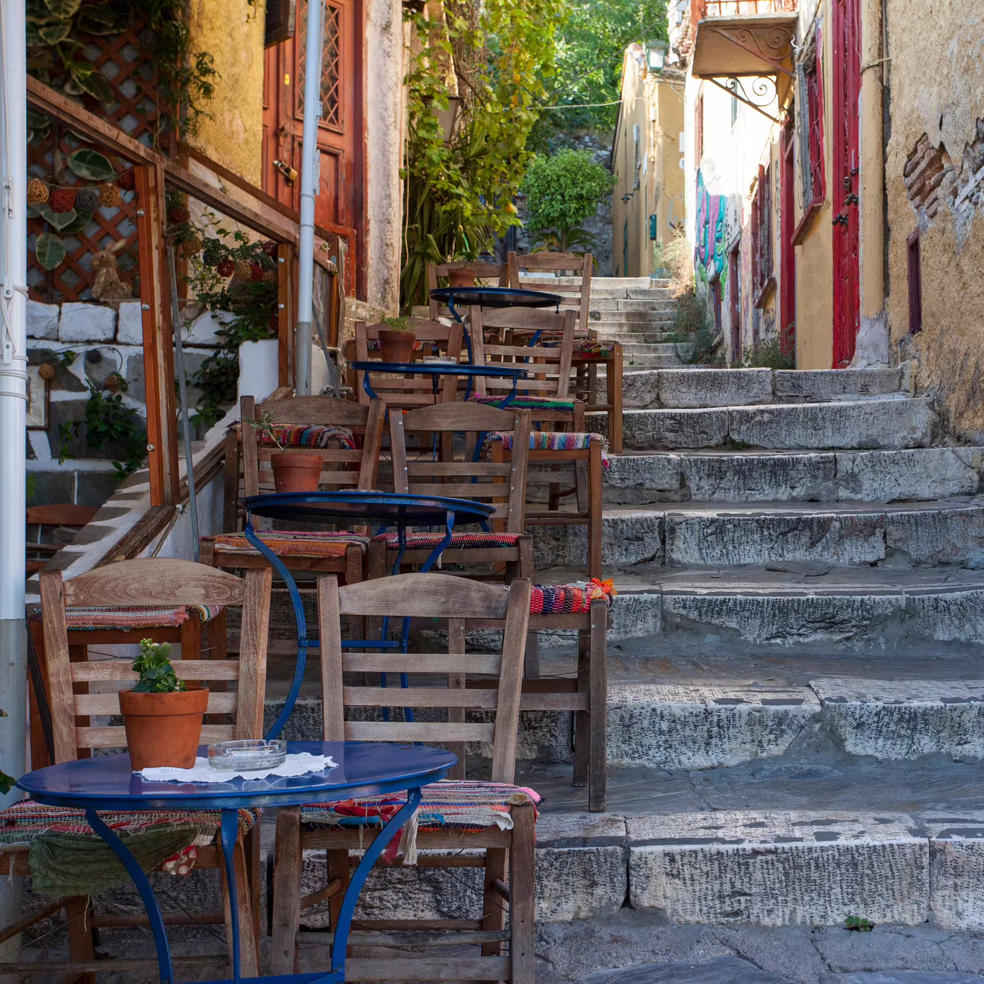 Charming Plaka stairway cafe tables in Athens, a scenic walk on the Taste of Athens small-group afternoon food tour