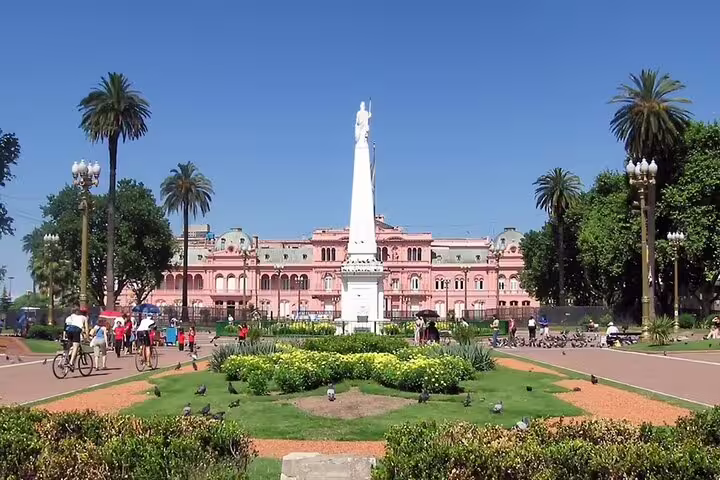 Plaza de Mayo gardens with the Pirámide de Mayo and Casa Rosada on a Buenos Aires full day tour