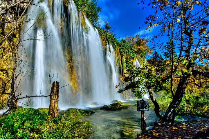 Plitvice Lakes National Park admission ticket view of a powerful waterfall beside a wooden boardwalk