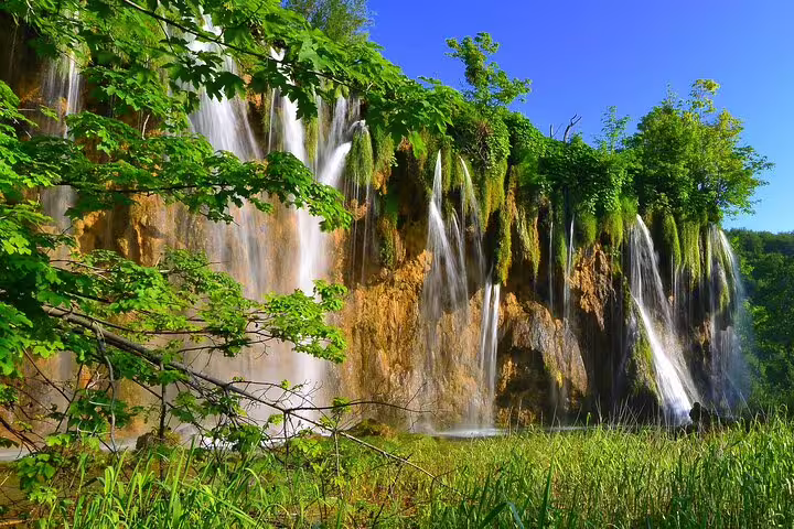 Plitvice Lakes National Park admission ticket view of lush cliff waterfalls and clear pools in Croatia