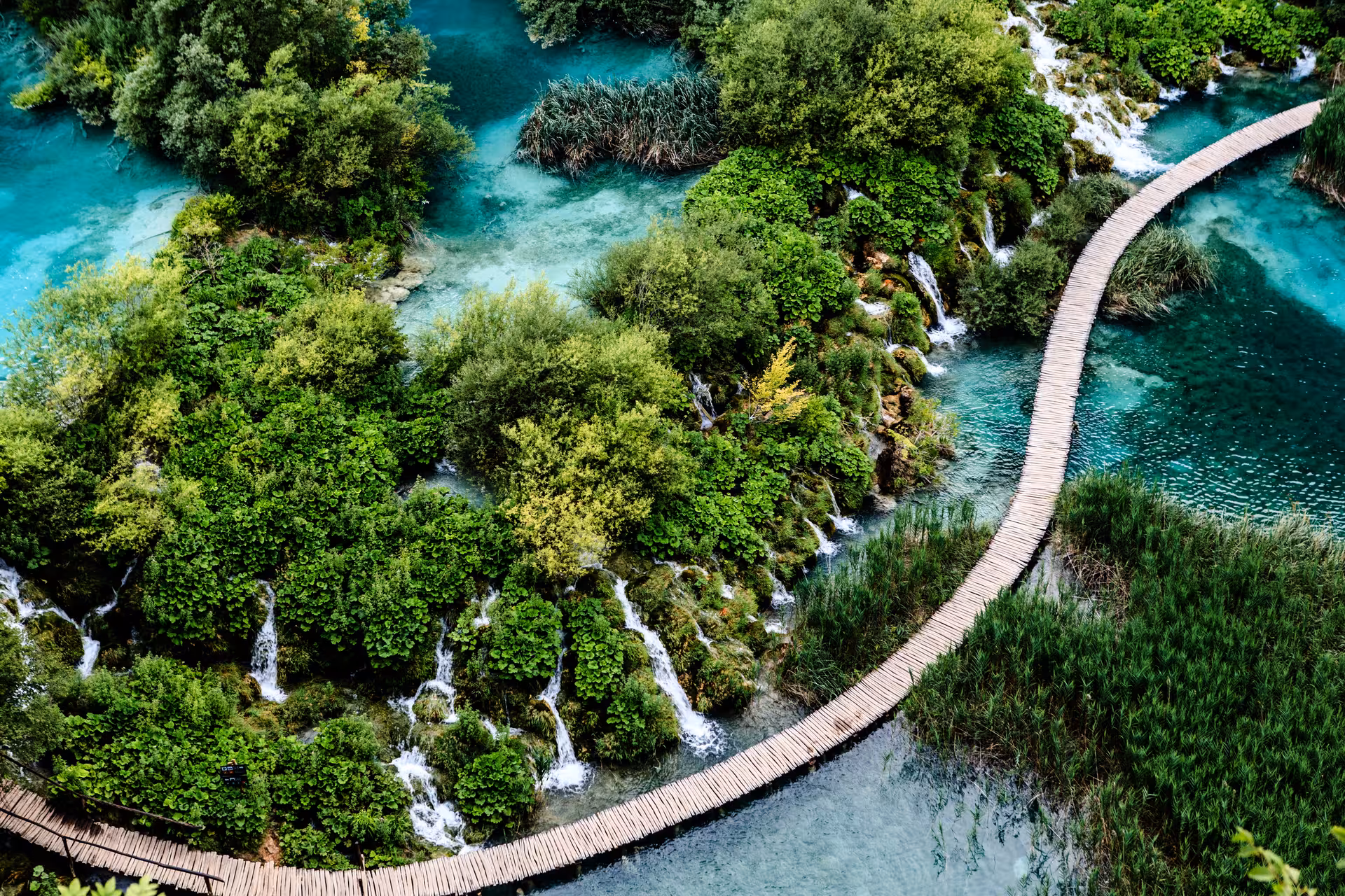 Aerial view of Plitvice Lakes boardwalk over turquoise pools and cascades on guided day trip from Split