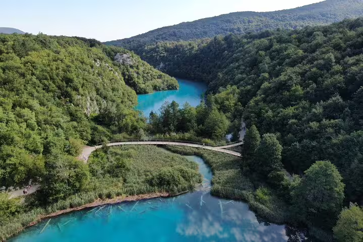 Wooden boardwalk over turquoise water in Plitvice Lakes National Park, Croatia, included with admission ticket
