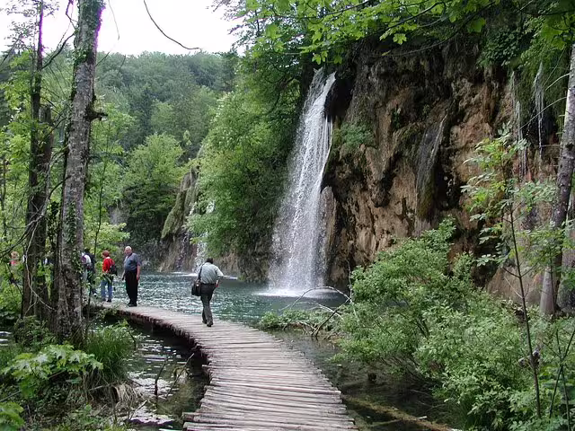 Wooden boardwalk by waterfall and turquoise lakes on Plitvice Lakes day trip from Zadar and Biograd