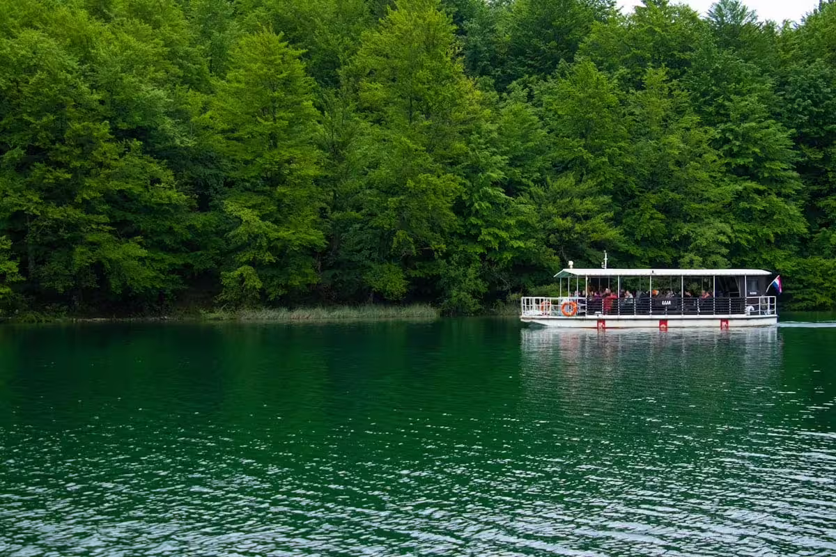 Electric boat cruise on emerald lake at Plitvice Lakes National Park, Croatia, on guided group tour